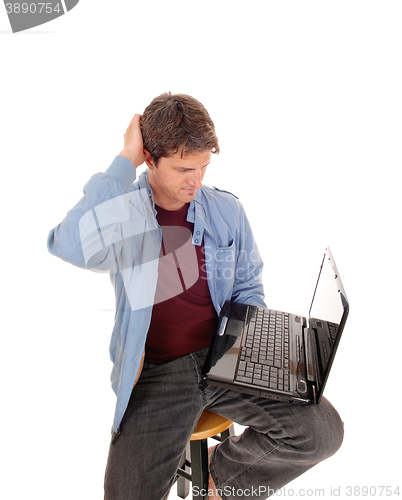 Image of Man is wondering what is on the laptop.