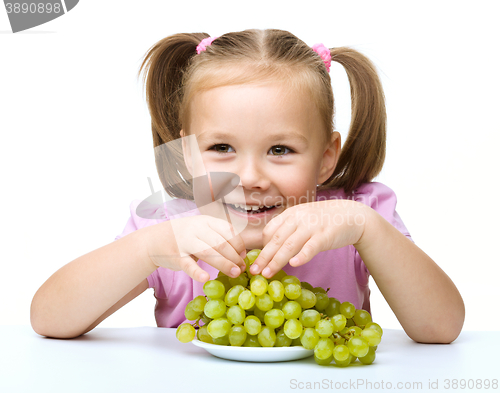 Image of Little girl is eating grapes