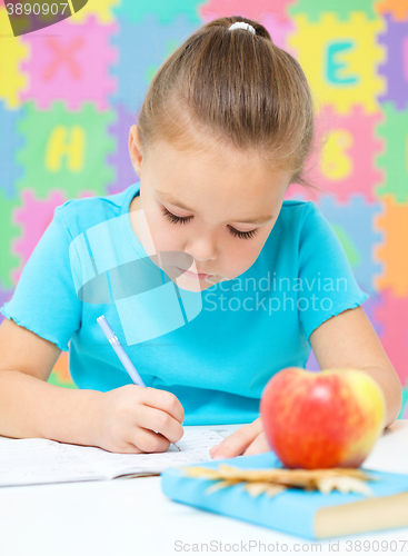 Image of Little girl is writing using a pen