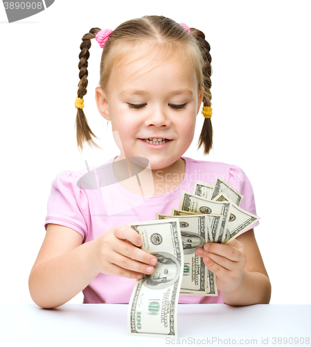 Image of Little girl is counting dollars