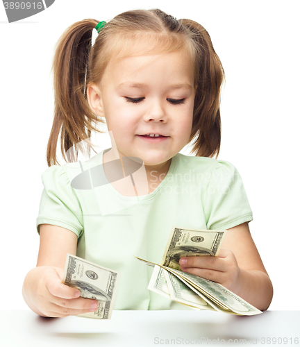 Image of Little girl is counting dollars