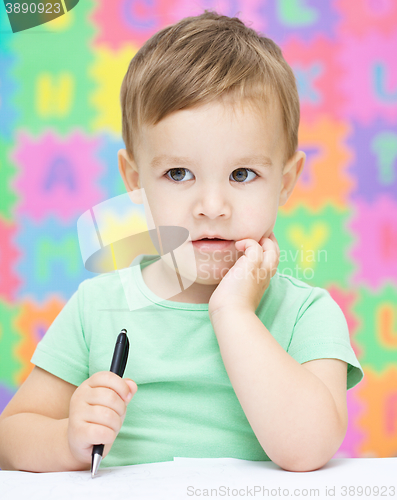 Image of Little boy is writing on his copybook