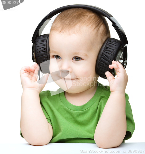 Image of Cute little boy enjoying music using headphones