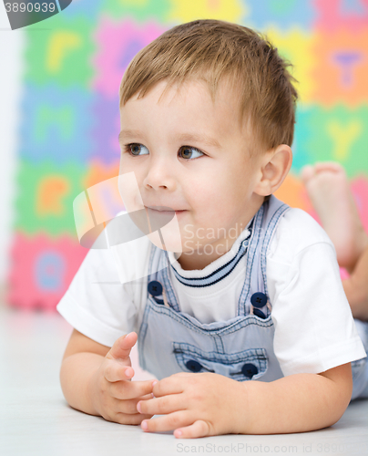 Image of Little boy is laying on a floor