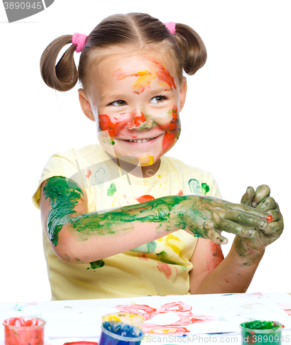 Image of Portrait of a cute girl playing with paints