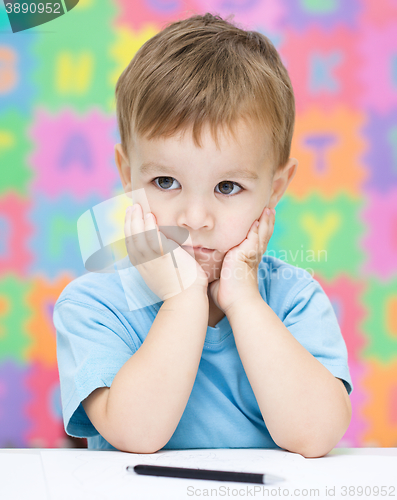 Image of Little girl is writing using a pen