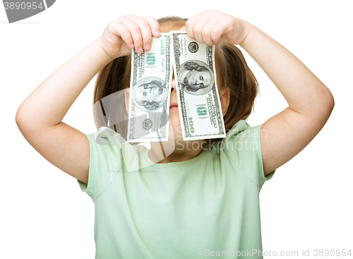 Image of Little girl is covering her eyes with dollars