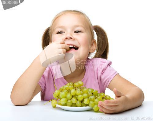 Image of Little girl is eating grapes