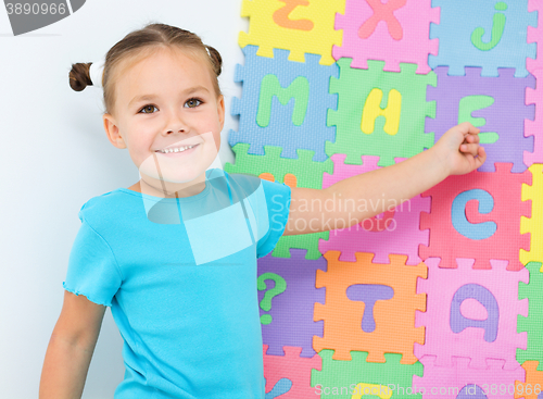 Image of Little girl is showing letter E on the alphabet