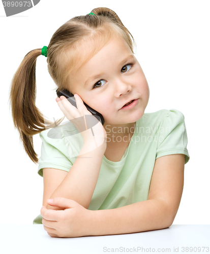 Image of Cute little girl is talking on a cell phone