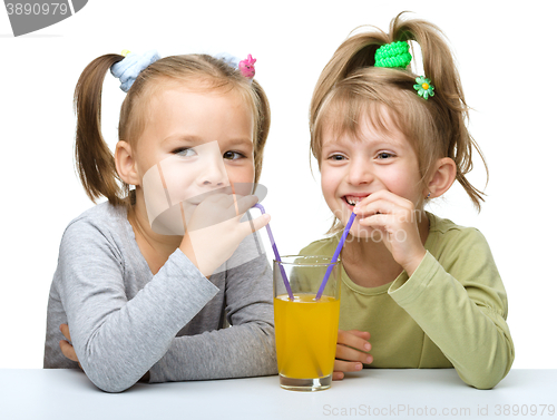 Image of Two Little girls are drinking orange juice