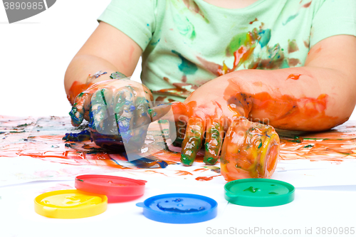 Image of Little boy is playing with paints