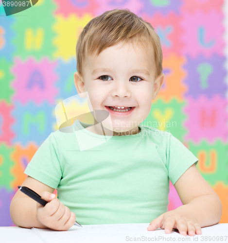 Image of Little boy is writing on his copybook