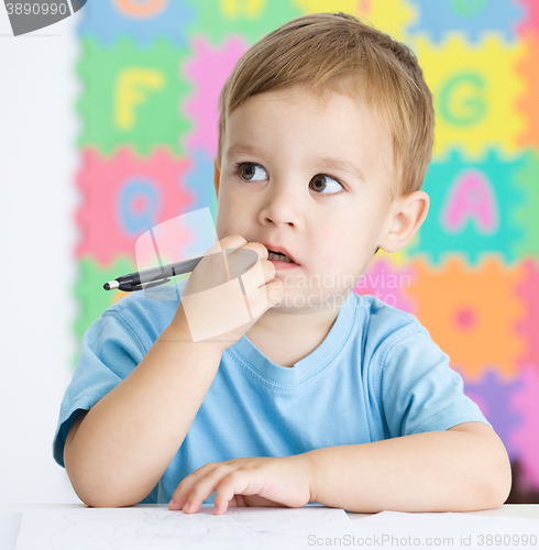 Image of Little boy is writing on his copybook