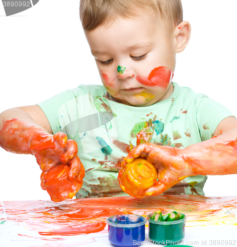 Image of Little boy is playing with paints