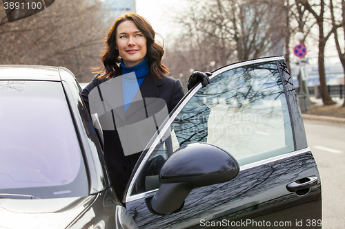 Image of beautiful businesswoman near car