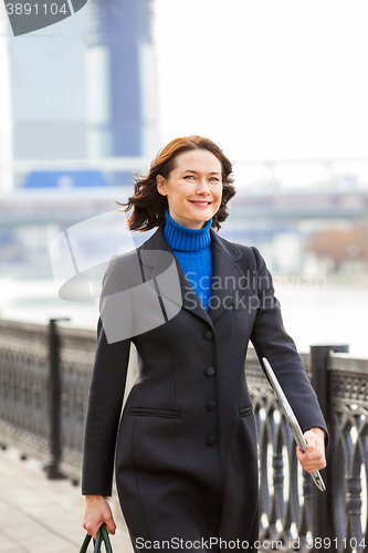 Image of smiling middle-aged woman in a dark coat