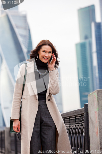 Image of smiling middle-aged woman talking on a mobile phone
