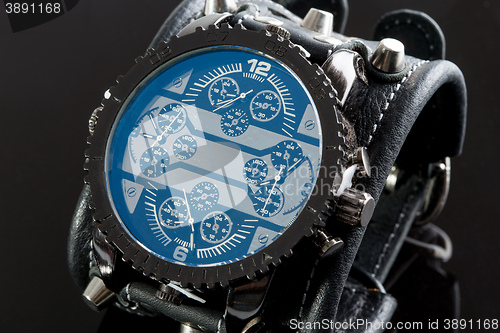 Image of close-up of wristwatch on a black background