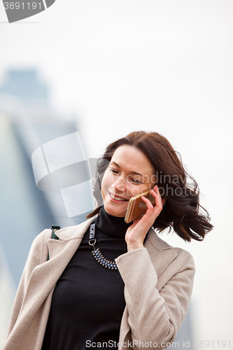Image of beautiful smiling woman talking on a mobile phone