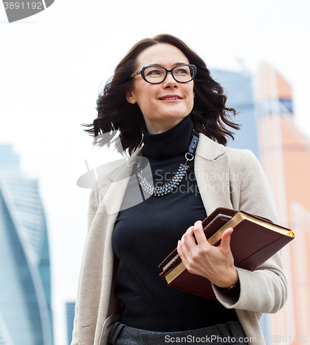 Image of smiling middle-aged woman with books