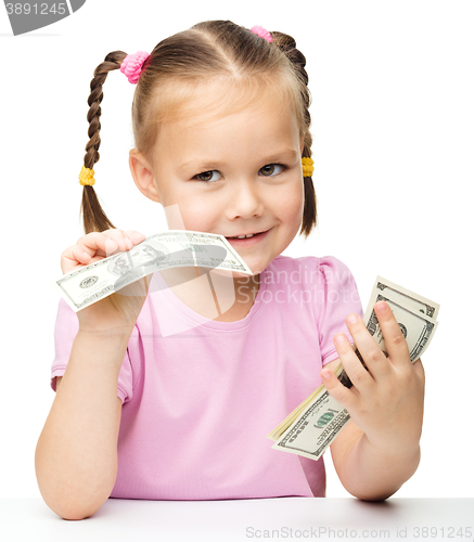 Image of Little girl is counting dollars