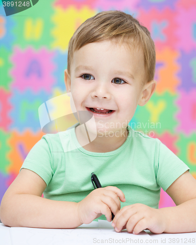 Image of Little boy is writing on his copybook