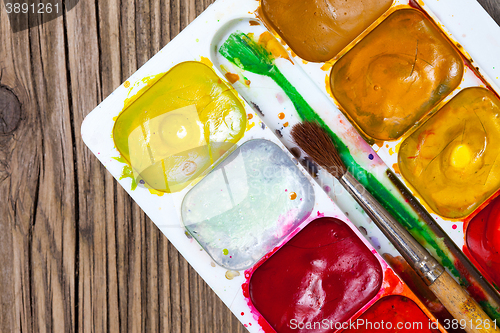 Image of watercolors, paint-box and a brush