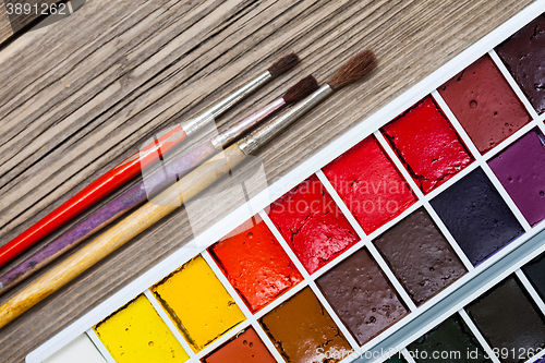 Image of aquarelle paint-box and three brushes