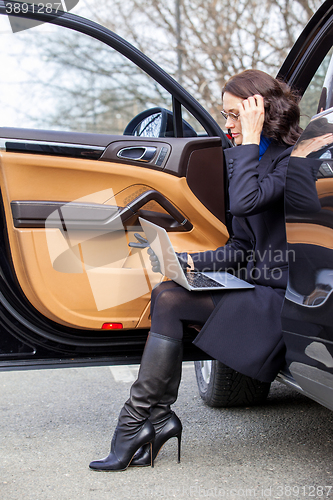 Image of woman sitting on the threshold of the car