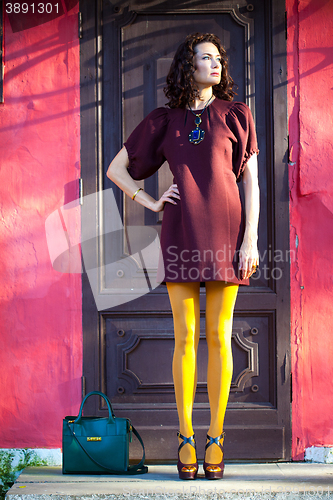 Image of woman in a fashionable burgundy dress and orange pantyhose