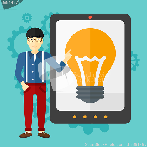 Image of Man pointing at tablet computer with light bulb on screen.