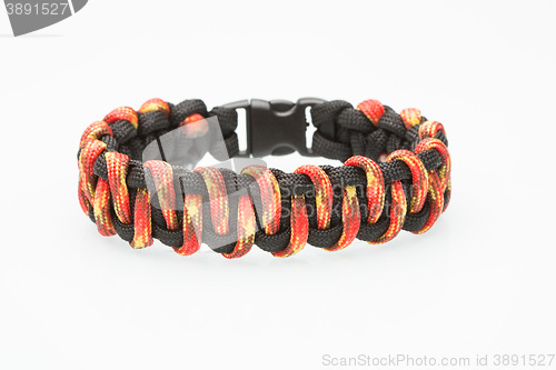 Image of black and orange braided bracelet on white background