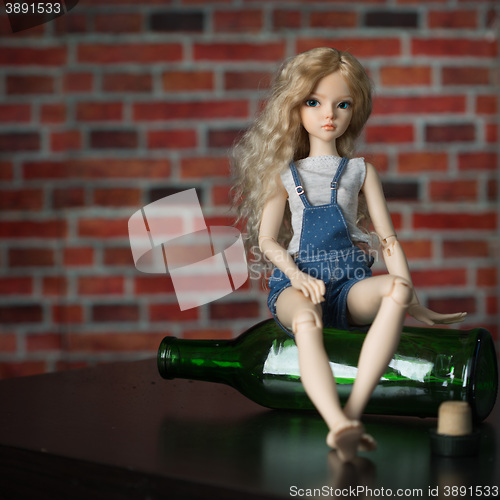 Image of doll with a bottle. the concept of alcoholism