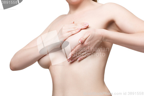 Image of Examining breasts. Close-up of young shirtless woman examining her breasts while. Isolated white background