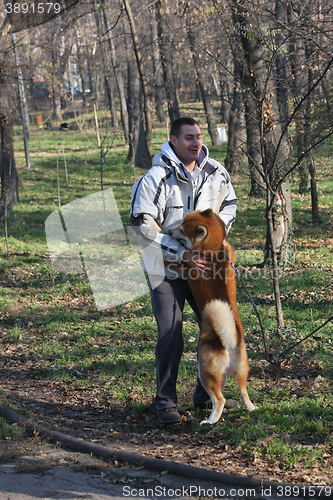 Image of Man and joyful dog in public park