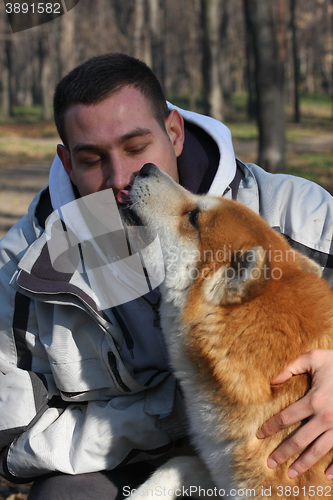 Image of Man and joyful dog in public park