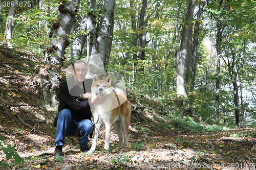 Image of Man and dog enjoying in the forest