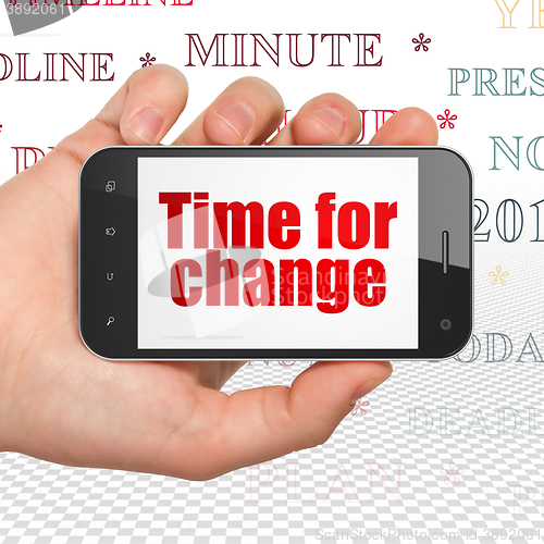 Image of Timeline concept: Hand Holding Smartphone with Time for Change on display