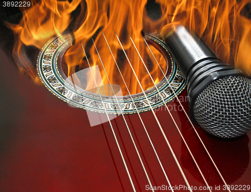 Image of guitar and microphone burning in the fire