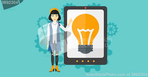 Image of Woman pointing at tablet computer with light bulb on screen.