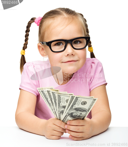 Image of Little girl is counting dollars