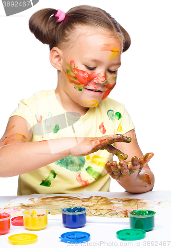 Image of Portrait of a cute girl playing with paints