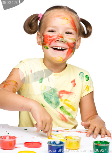 Image of Portrait of a cute girl playing with paints