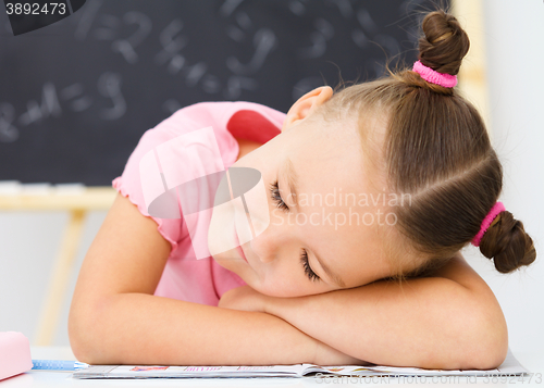 Image of Little girl is sleeping on her writing-book