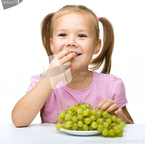 Image of Little girl is eating grapes