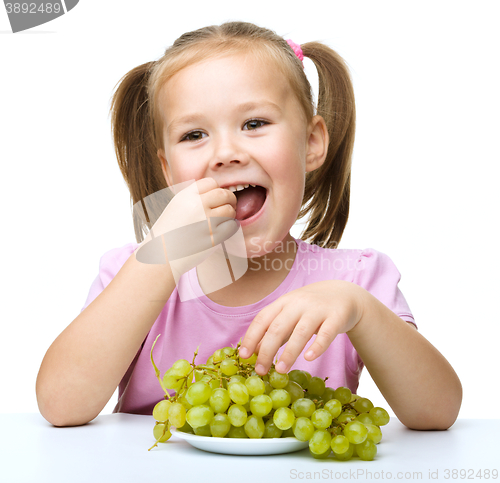 Image of Little girl is eating grapes