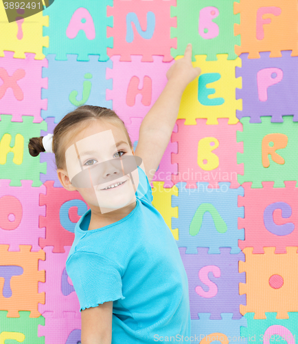 Image of Little girl is pointing at letter B