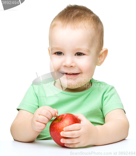 Image of Portrait of a cute little boy with yellow apples