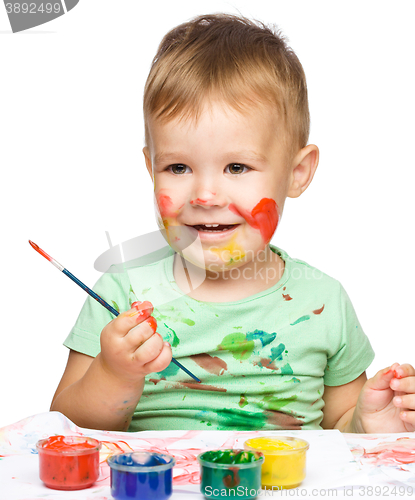 Image of Little boy is playing with paints